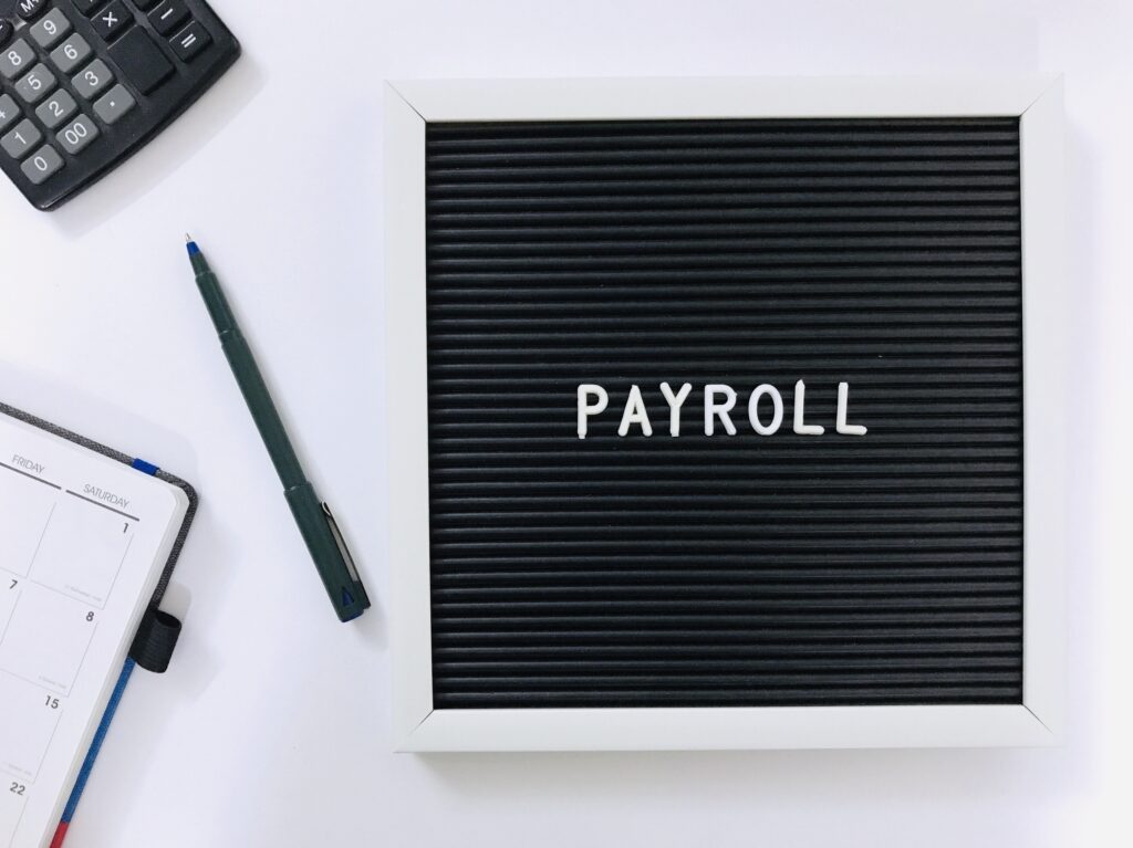 A diary book, pen and calculator flat lay which represents Payroll concept 88